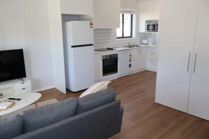 a living room with a couch and a kitchen at Proline Serviced Apartments 
