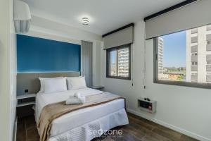 Un dormitorio con una cama con un animal de peluche encima. en Alojamientos completos y modernos en edificio con gimnasio - MCP, en Petrópolis 12 fotos más