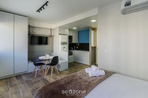 Un dormitorio con una cama y una mesa con sillas. en Alojamientos completos y modernos en edificio con gimnasio - MCP, en Petrópolis
