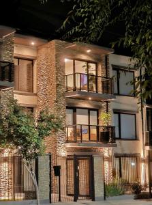 a brick building with a balcony with lights on it at ANDES Apartments - PATAGONIA in San Martín de los Andes