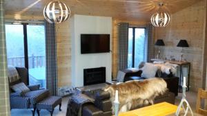 a living room with a couch and a fireplace at Sòghail Luxury Lodge and Balquhidder Mhor with Hot Tub in Kingshouse +13 photos