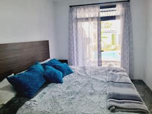 Un dormitorio con una cama con almohadas azules y una ventana. en Casa Luna Mía, en Atlixco 43 fotos más