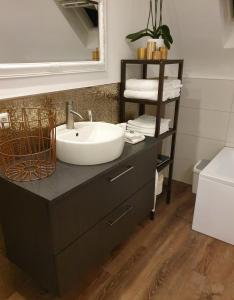 La salle de bains est pourvue d'un lavabo blanc sur une armoire noire. dans l'établissement Licata Trade fair accommodation - Messezimmer, à Düsseldorf