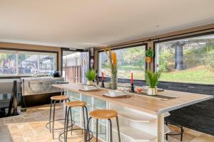 a kitchen with a large table and some stools at Péniche insolite sur la Seine - près de Paris in Asnières-sur-Seine