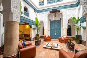 a lobby with chairs and tables in a building at Dar Alhambra Riad Medina in Marrakech