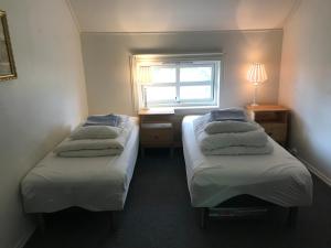 twee bedden in een kleine kamer met een raam bij Strand farm, sea view and boat rental in Averoy