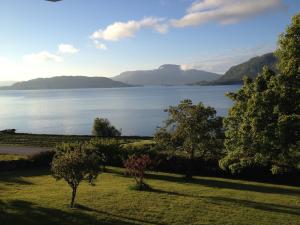 een uitzicht op een waterlichaam met bomen en bergen bij Strand farm, sea view and boat rental in Averoy +20 foto's