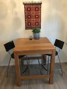 een houten tafel met twee stoelen en een potplant bij Strand farm, sea view and boat rental in Averoy