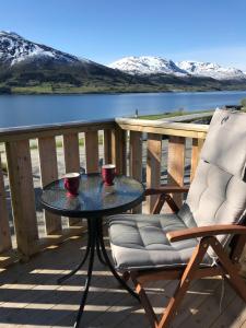 een tafel en een stoel op een terras met een meer bij Strand farm, sea view and boat rental in Averoy