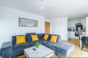 a living room with a blue couch and yellow pillows at X1 Humble Abode in Manchester