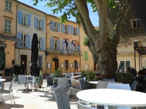 a patio with tables and chairs in front of a building at Le Cabanon des Collines in Signes