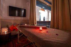 a room with a table with candles and a tv at Dar Alhambra Riad Medina in Marrakech