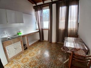 a kitchen with a table and a sink and a window at Hotel Torre in Vulcano