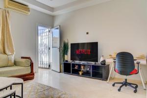 a living room with a television and a chair at jaws wave agadir 2 in Agadir