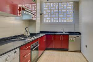 a kitchen with red cabinets and a sink at jaws wave agadir 2 in Agadir