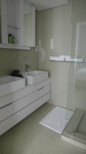 a white bathroom with a sink and a mirror at ITowers Luxury Apartment 2 in Gaborone