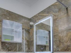 a bathroom with a mirror and a window and a stone wall at jaws wave agadir 2 in Agadir +41 photos