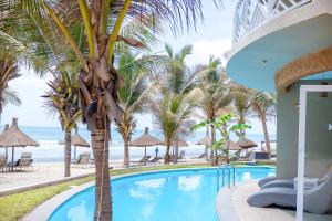 una piscina con palme e la spiaggia di Balafon Beach Resort a Kololi