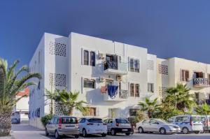 a white building with cars parked in front of it at jaws wave agadir 2 in Agadir