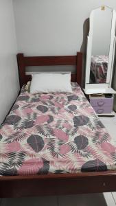 una camera con un letto e un piumone rosa e bianco di Quarto em casa de família a Belém