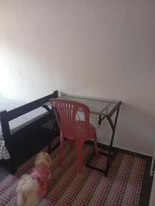 a small table and a red chair next to a bed at O cafofo in Sao Paulo +3 photos