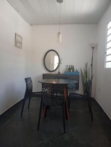 a dining room with a table and chairs and a mirror at O cafofo in Sao Paulo