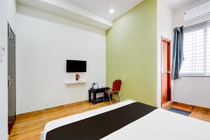 Un dormitorio con una cama, un escritorio y un televisor. en Super Collection O BN Reddy Hyderabad, en Hyderabad