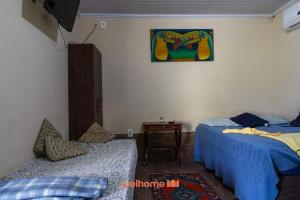 a bedroom with two beds and a table and a picture at Suite em Macae com mini fazendinha e piscina in Sana