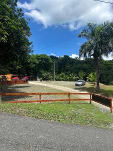 a wooden fence with a car parked next to a palm tree at Campo Adentro Cabin 2 Private Jacuzzi in Aguada +25 photos