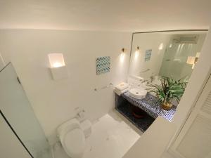 a white bathroom with a toilet and a sink at Apartment in the Historical Center of Cartagena in Cartagena de Indias +8 photos