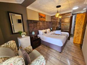 um quarto de hotel com uma cama e um sofá em Bosveld In Die Stad Lodge em Alberton mais 69 fotografias