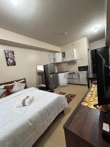 een slaapkamer met een groot bed en een keuken bij New Lovely Studio adj Ayala CDO in Cagayan de Oro +19 foto's