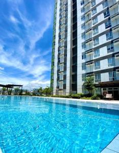 een groot zwembad voor een hoog gebouw bij New Lovely Studio adj Ayala CDO in Cagayan de Oro