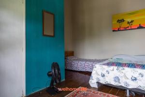 a room with two beds and a blue wall at Suite em Macae com cavalos e proximo a cachoeiras in Sana