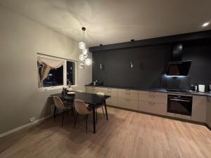 a kitchen with a table and chairs and a black wall at The apartment in the middle of Lofoten in Vestvågøya