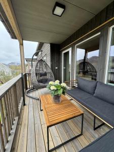 a porch with a couch and chairs and a table at The apartment in the middle of Lofoten in Vestvågøya