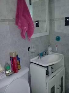 Un baño con un inodoro blanco y un lavabo. en Comparto mi casita, en Salta