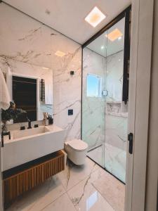 a bathroom with a toilet and a sink and a shower at Loft do Edu in Ortigueira +4 photos