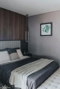 a bedroom with a large bed and a picture on the wall at Loft do Edu in Ortigueira