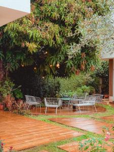 a group of benches sitting under a tree at Loft do Edu in Ortigueira