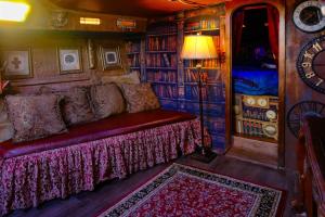 a red couch in a room with a book shelf at The Victorian Voyager in Kemah