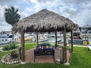 a table and bench under a thatch hut at The Victorian Voyager in Kemah