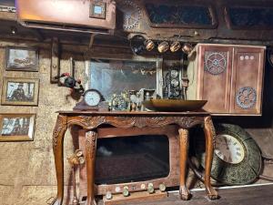 an old tv with a mirror and clocks on a wall at The Victorian Voyager in Kemah