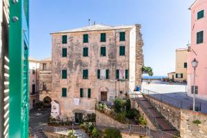 an old stone building in the middle of a street at La Casetta Verde con Vista Mare - Nel cuore del Parasio e delle Logge di Santa Chiara in Imperia