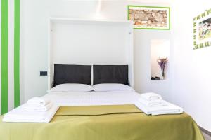 a bed with two white towels on top of it at La Casetta Verde con Vista Mare - Nel cuore del Parasio e delle Logge di Santa Chiara in Imperia