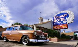 un coche viejo aparcado frente a un motel en Holiday Motel, en Elko