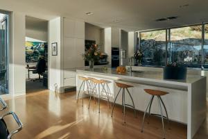 een keuken met een aanrecht en barkrukken bij Executive Home with Stunning Harbour views in Diamond Harbour