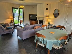 a living room with a table and a couch at Maison familiale avec jardin - Proche Centre Pau in Gelos