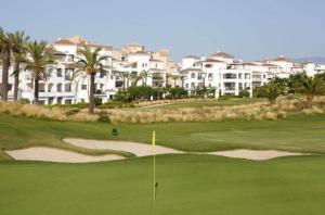 a view of a golf course with condos in the background at Villa Marrajo La Torre Golf Resort in Torre-Pacheco
