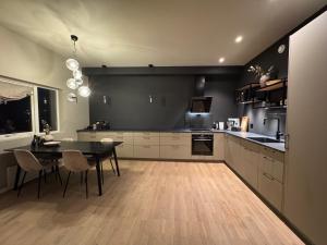 a kitchen with a table and a black wall at The apartment in the middle of Lofoten in Vestvågøya